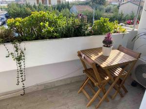 een kleine tafel en stoelen op een balkon met bloemen bij Appartamento Luxury White in Viareggio