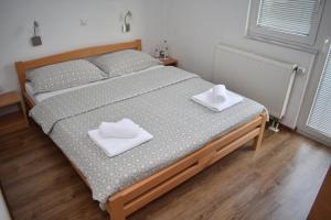 ein Schlafzimmer mit einem Bett mit zwei weißen Handtüchern darauf in der Unterkunft Apartmani Vila in Kupres