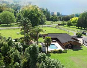 an aerial view of a house with a swimming pool at Palms on Bruntwood in Tamahere
