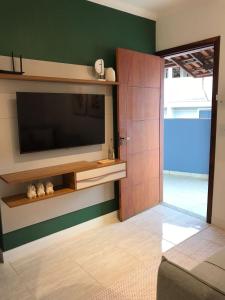 a living room with a flat screen tv on a wall at Sinta-se em casa. in Barbacena