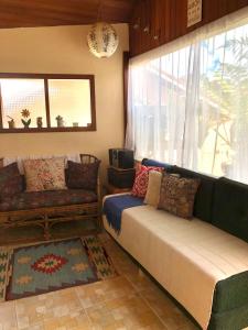 een woonkamer met een bank en een raam bij Recanto Luar in Camanducaia