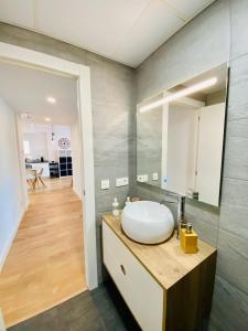 a bathroom with a white sink and a mirror at Apartamento HC13 - PUERTA PURCHENA in Almería