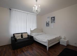 1 dormitorio con 1 cama, 1 silla y 1 lámpara de araña en Cozy Homestay at Andel Prague, en Praga
