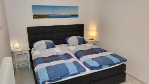1 dormitorio con 2 camas y un cuadro en la pared en Komfortable & moderne Ferienwohnung in Markdorf - Familie Hildebrand, en Markdorf