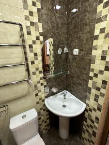 een badkamer met een wit toilet en een wastafel bij Jermuk Mini Apartment in Dzjermoek