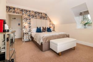 a bedroom with a large bed with blue pillows at Wheatlands Lodge-Windermere - Award Winning - Adult Only - Free Car Park in Windermere