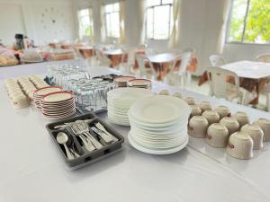 a white table with plates and dishes on it at Pousada Natalli in Cabo Frio