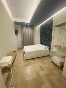 una camera con letto bianco, tavolo e scaffali di Apulia 35 a Bari