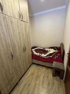 a small bedroom with a bed and wooden cabinets at Jermuk Mini Apartment in Jermuk