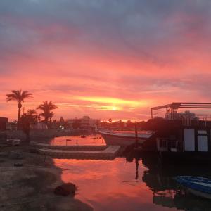 a sunset over a harbor with boats in the water at Best Kept Secret by the Sea in Famagusta