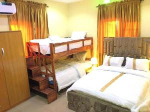 a bedroom with two beds and a bunk bed at Scepter Apartments in Apena