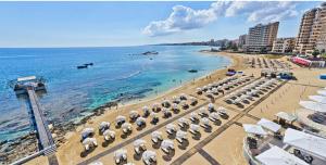 a beach with a bunch of umbrellas and the ocean at Best Kept Secret by the Sea in Famagusta