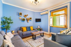 uma sala de estar azul com dois sofás e uma mesa em Inglaterra by Central Hill Apartments em Lisboa