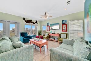 a living room with two couches and a tv at The Clubhouse - Fort Morgan in Gulf Shores