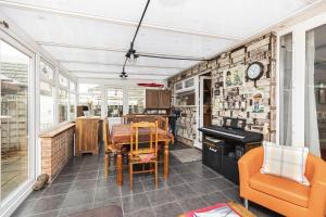 une salle à manger avec une table et un piano dans l'établissement Cozy Cottage, Secure Garden, Dog Freindly, à Bournemouth