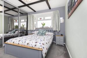 a bedroom with two beds and two windows at Cozy Cottage, Secure Garden, Dog Freindly in Bournemouth