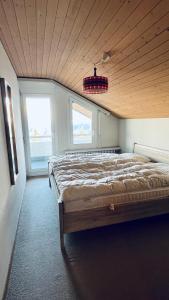 um quarto com uma cama grande e 2 janelas em Apartmenthaus Gauenpark - CharmingStay em Flumserberg
