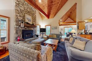 ein Wohnzimmer mit Sofas und einem Steinkamin in der Unterkunft Ski You Later in Strattonwald