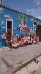 a group of people sitting in front of a building at Hostel Litoral in Peruíbe