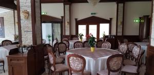 a dining room with tables and chairs and a table with a vase at Hotel TROESMIS 