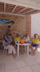 a group of people sitting around a table at Hostel Litoral in Peruíbe