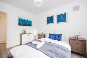 a bedroom with a bed with blue and white sheets at 3 Bedroom Flat Near Old Street in London