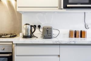 a kitchen counter with a toaster and a tea kettle at 3 Bedroom Flat Near Old Street in London