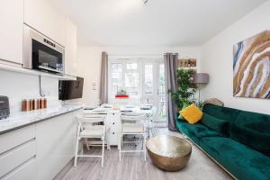 a living room with a green couch and a table at 3 Bedroom Flat Near Old Street in London