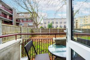 a balcony with a table and chairs and a fence at 3 Bedroom Flat Near Old Street in London