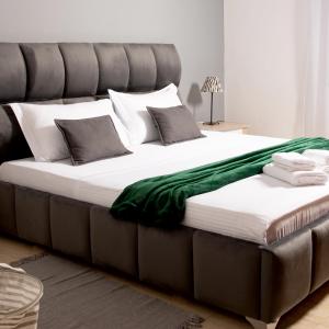 - un grand lit avec une couverture verte dans l'établissement Maris Apartment, à Tirana