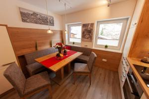 cocina y comedor con mesa y sillas en Appartement Gimpl, en Fusch an der Glocknerstrasse