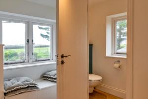 ein Badezimmer mit WC und zwei Fenstern in der Unterkunft Finest Retreats - Dingles Cottage in Philleigh + 40 Fotos
