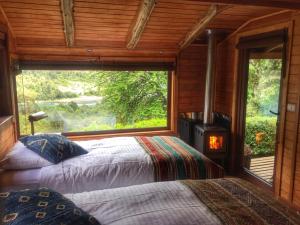 1 dormitorio con 1 cama y estufa de leña en Barraco Lodge, en Las Gualas