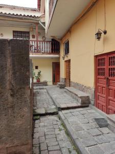 Une allée dans une maison avec une porte rouge dans l'établissement Qosqo Apartments 3, à Cusco