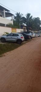 eine Reihe geparkter Autos auf einem Parkplatz in der Unterkunft Residencial Jardim Imbassai 4 apt mobiliado com piscina in Mata de Sao Joao