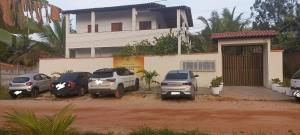 a group of cars parked in front of a house at Residencial Jardim Imbassai 4 apt mobiliado com piscina in Mata de Sao Joao