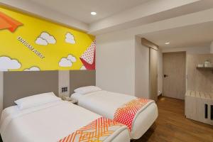 una camera con due letti e una parete con nuvole di Hotel bule bell a Patna