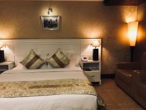 Habitación de hotel con cama y sofá en Hotel bule bell, en Patna