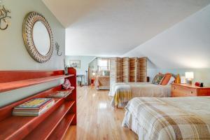 a bedroom with two beds and a mirror on the wall at Riverfront Kingston Cottage w/ Deck, 2 Mi to Beach in Kingston