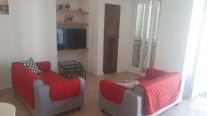 sala de estar con 2 sillas y TV en Casa Padulella (4 appartements), en Moriani Plage