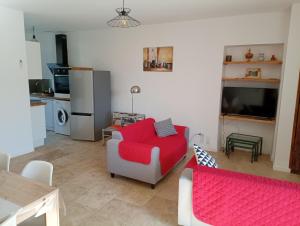 sala de estar con sofá rojo y cocina en Casa Padulella (4 appartements), en Moriani Plage