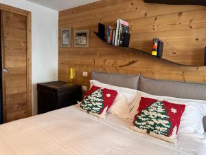 a bedroom with a bed with two christmas pillows on it at Maison Rododendro Elegant in Breuil-Cervinia