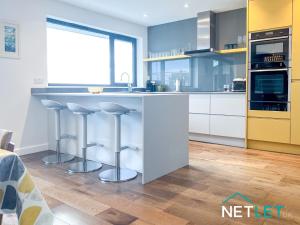 a kitchen with a counter and stools in it at Gannet's Lodge in Pembrokeshire