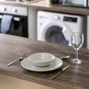 a bowl and a glass on a wooden counter with a table at Modern 4-bed house with garden & parking in Walsgrave on Sowe