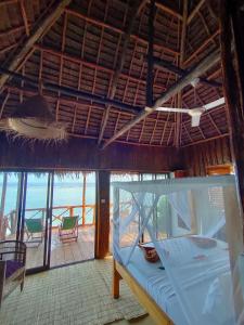 a bed in a room with a view of the ocean at Mtende Beach Bungalow océan view in Mtende