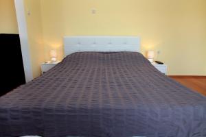 duże łóżko w sypialni z 2 stolikami nocnymi w obiekcie Rooms Carija w Trogirze