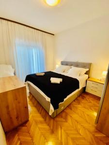 1 dormitorio con 1 cama grande y suelo de madera en Apartments Dalmatia, en Kaštela