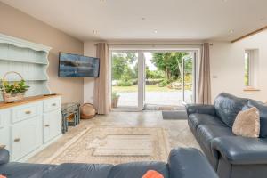 a living room with a couch and a tv at Maes-Y-Caerau in Criccieth