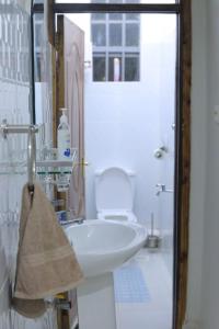 La salle de bains blanche est pourvue d'un lavabo et de toilettes. dans l'établissement 1BR Apartment, Canopy apartments Meru near KeMU university Main Campus, à Meru