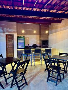 een patio met tafels en stoelen en een keuken bij Recanto das Margaridas in Pindoretama